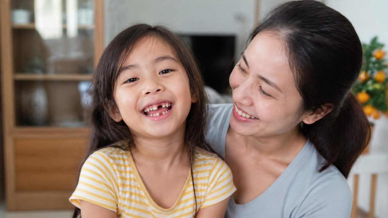 Bé gái cười hở khoảng trống răng sữa bên mẹ, trường hợp cần biết hàm giữ khoảng là gì - ảnh minh hoạ Nha khoa Bác sĩ Trung Long Biên