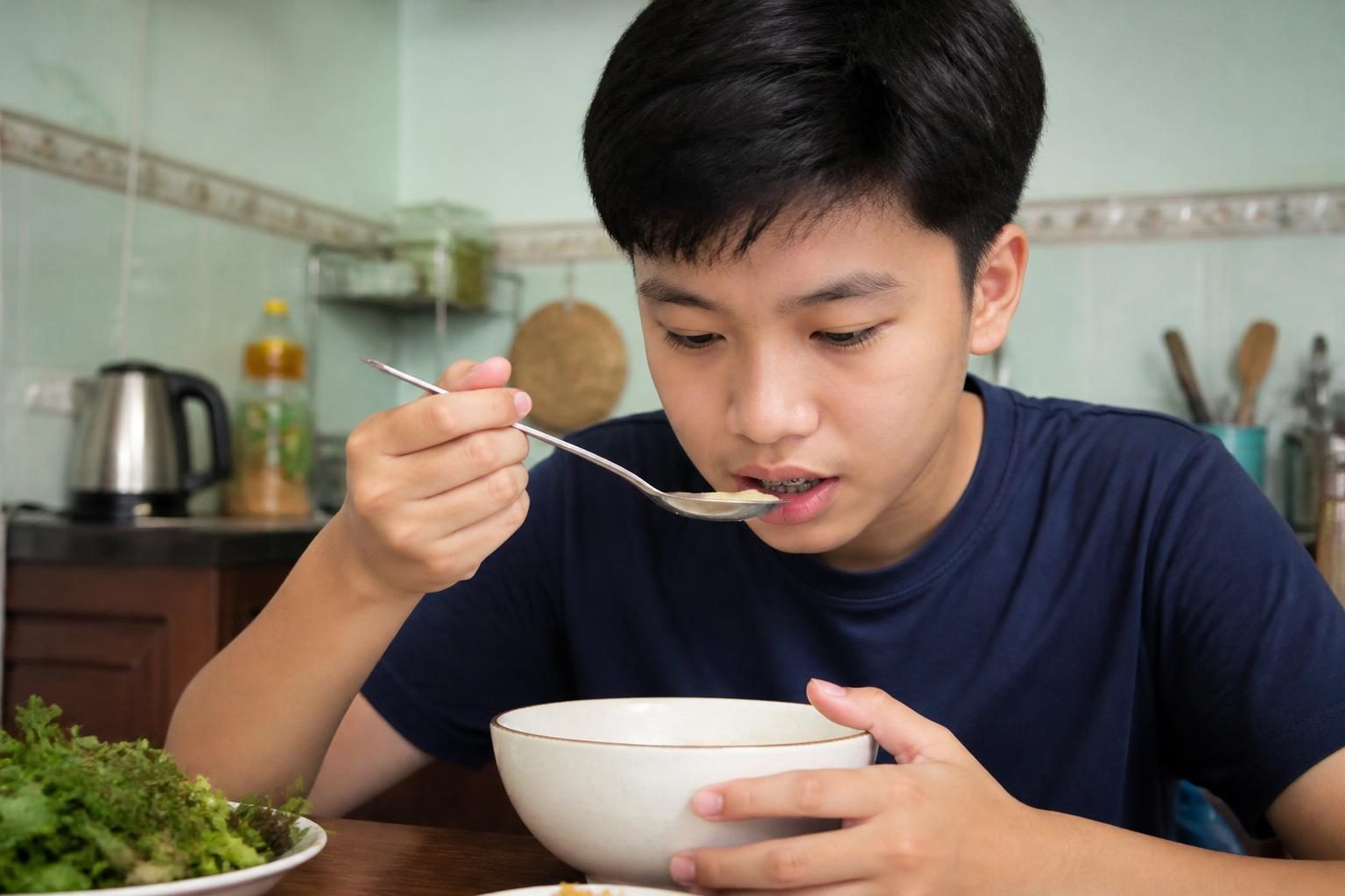 Cậu thiếu niên mới niềng răng ăn bát cháo mềm cẩn thận cho đỡ ê răng - ảnh minh hoạ người mới niềng răng
